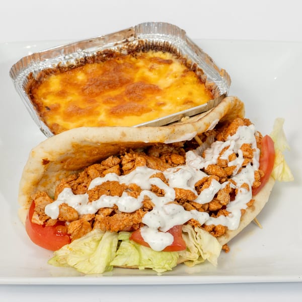 Ahsan's Halal chicken pita with white sauce, lettuce, and tomato, alongside a cheesy baked dish.