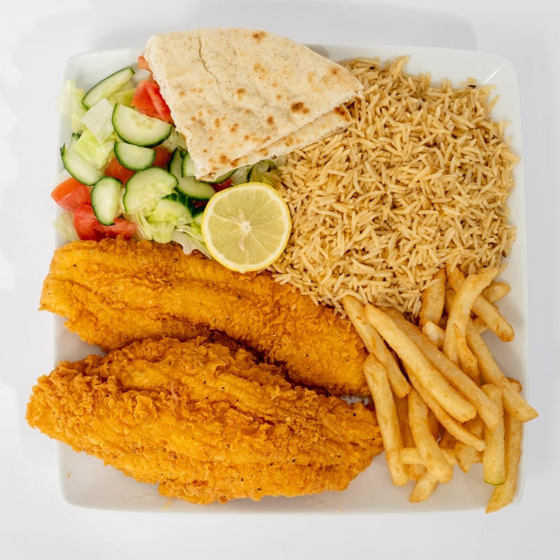 Ahsan's Halal fried fish platter with rice, fries, salad, pita bread, and a lemon slice.